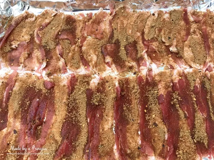 Man Candy Sweet Spicy Candied Bacon Recipe rub spices on bacon in cookie sheet