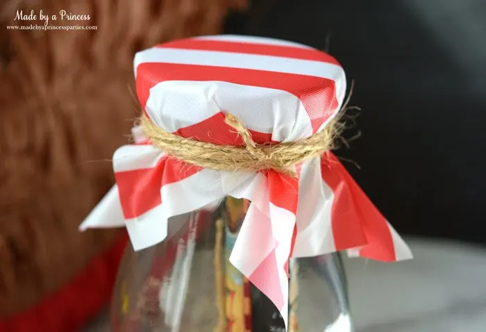 Pirate Bottle Invitations Party Idea place piece of plastic tablecloth on glass milk bottle and wrap twine around