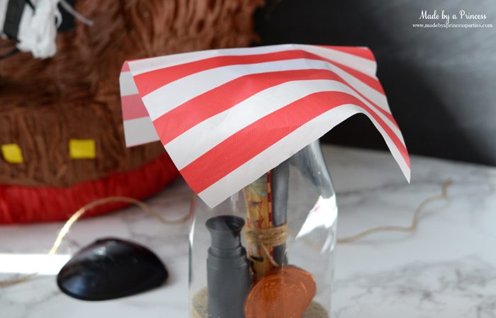 Pirate Bottle Invitations Party Idea place piece of plastic tablecloth on glass milk bottle