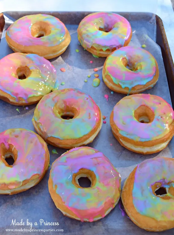 Rainbow Donuts Party Food Tutorial place donuts on wax paper on a cookie sheet to dry