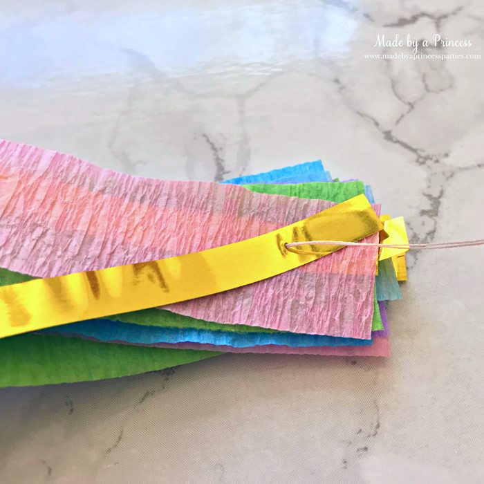 unicorn princess party hat idea tutorial layer crepe paper and gold fringe bring threaded needle through all layers