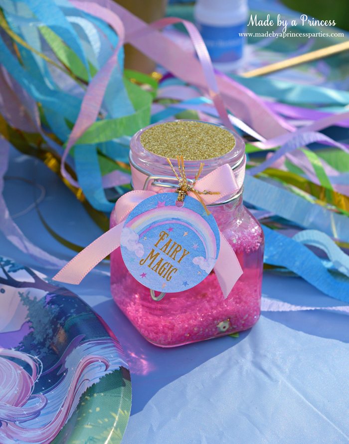 Glitter Fairy Jar Party Idea Tutorial filled with sequins and tied with a pretty ribbon and custom tag