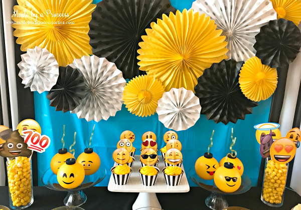 Emoji party ideas use yellow and black and white pinwheels to decorate