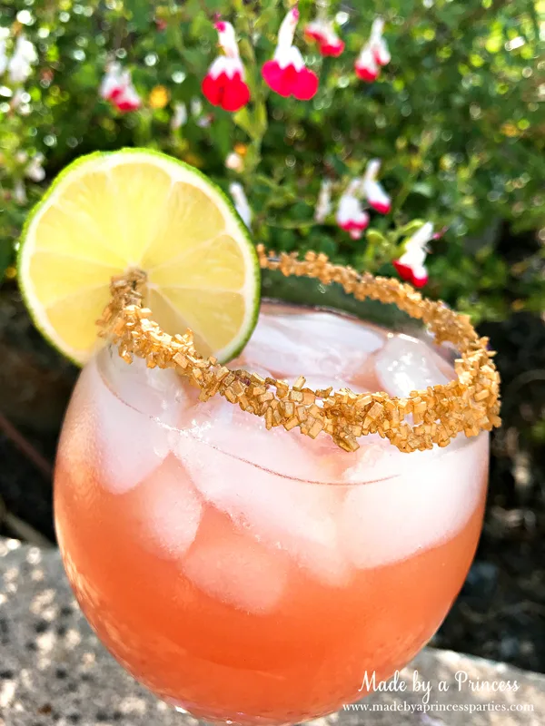 Copycat Disney Rose Gold Margarita garnish with gold sprinkles #disneycocktail #rosegoldmargarita #copycatdisneyrecipe @madebyaprincess