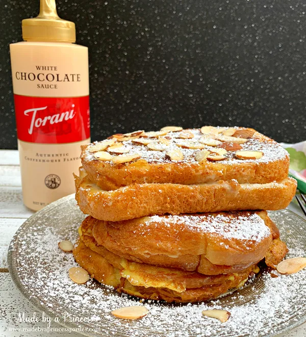 Garnish marzipan stuffed french toast with toasted almonds. powdered sugar and Torani White Chocolate Sauce