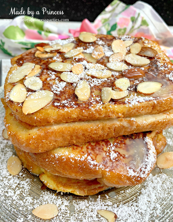 Sprinkle marzipan stuffed french toast with powdered sugar and toasted almonds and pour on the white chocolate sauce